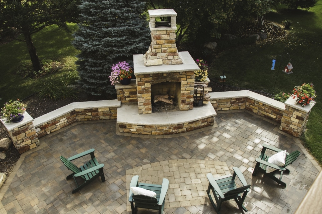 A paver inlay mimics the shape of this hearth creating unity between this patio and fireplace.