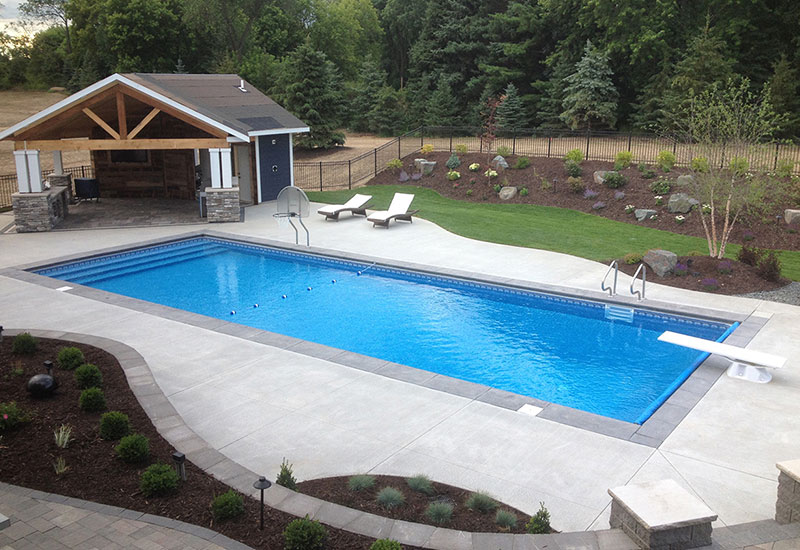 Aerial view of back yard pool and beautifully landscaped pool deck area