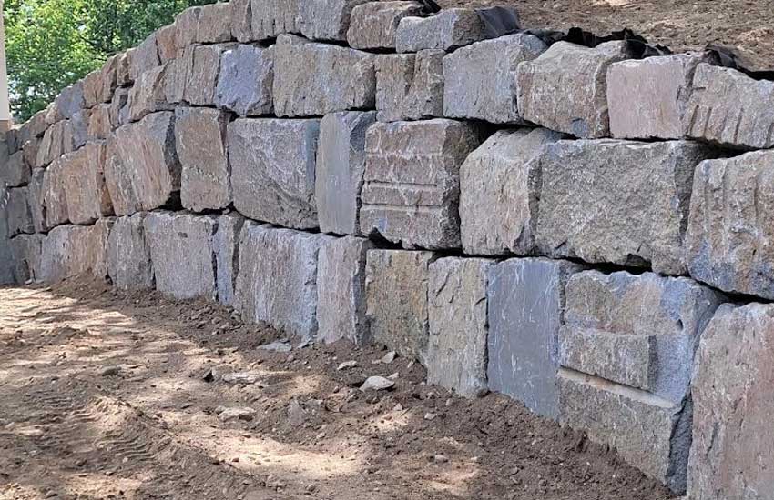 Residential granite boulder retaining wall landscape
