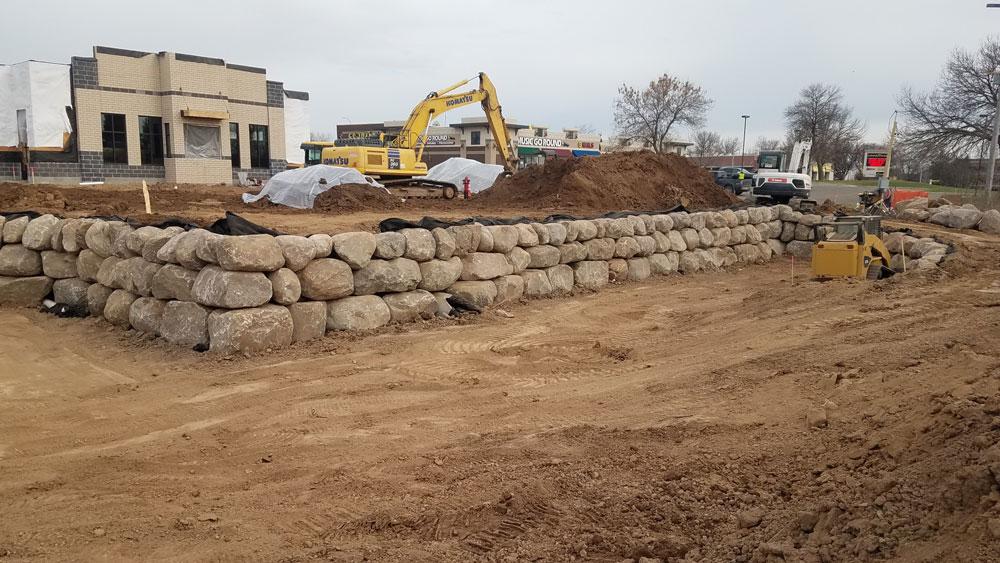Large-scale boulder retaining wall construction Minnesota