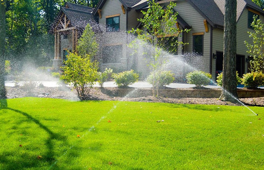 Lawn irrigation sprinkler system watering residential yard
